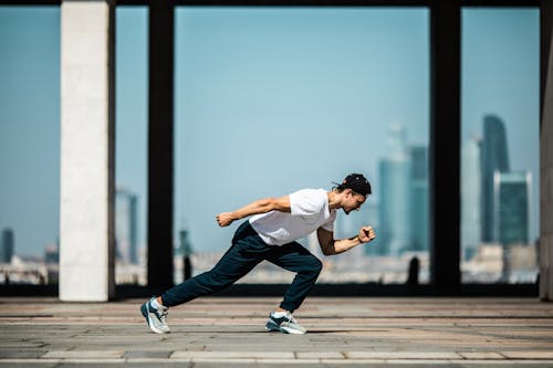 Homme En T Shirt Blanc Et Pantalon Noir En Position De Course