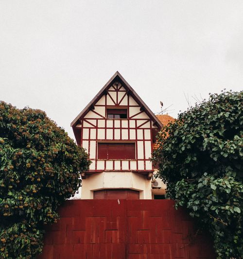 Free A traditional rustic cottage with wooden accents framed by lush greenery. Stock Photo