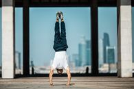 Man in Blue Denim Jacket and White Shorts In Handstand Position