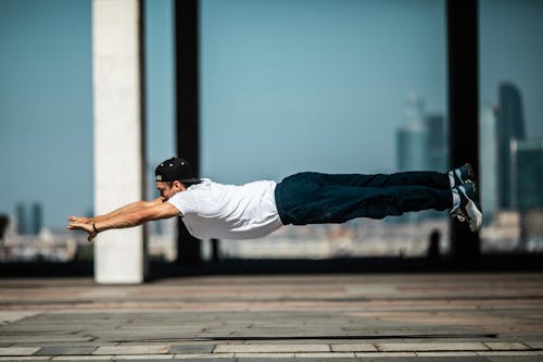 Man in White T-shirt and Blue Denim Jeans Doing Yoga