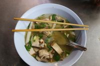 Bowl of rice-noodle soup with sliced pork and herbs — photo by M Snedelrev on Pexels