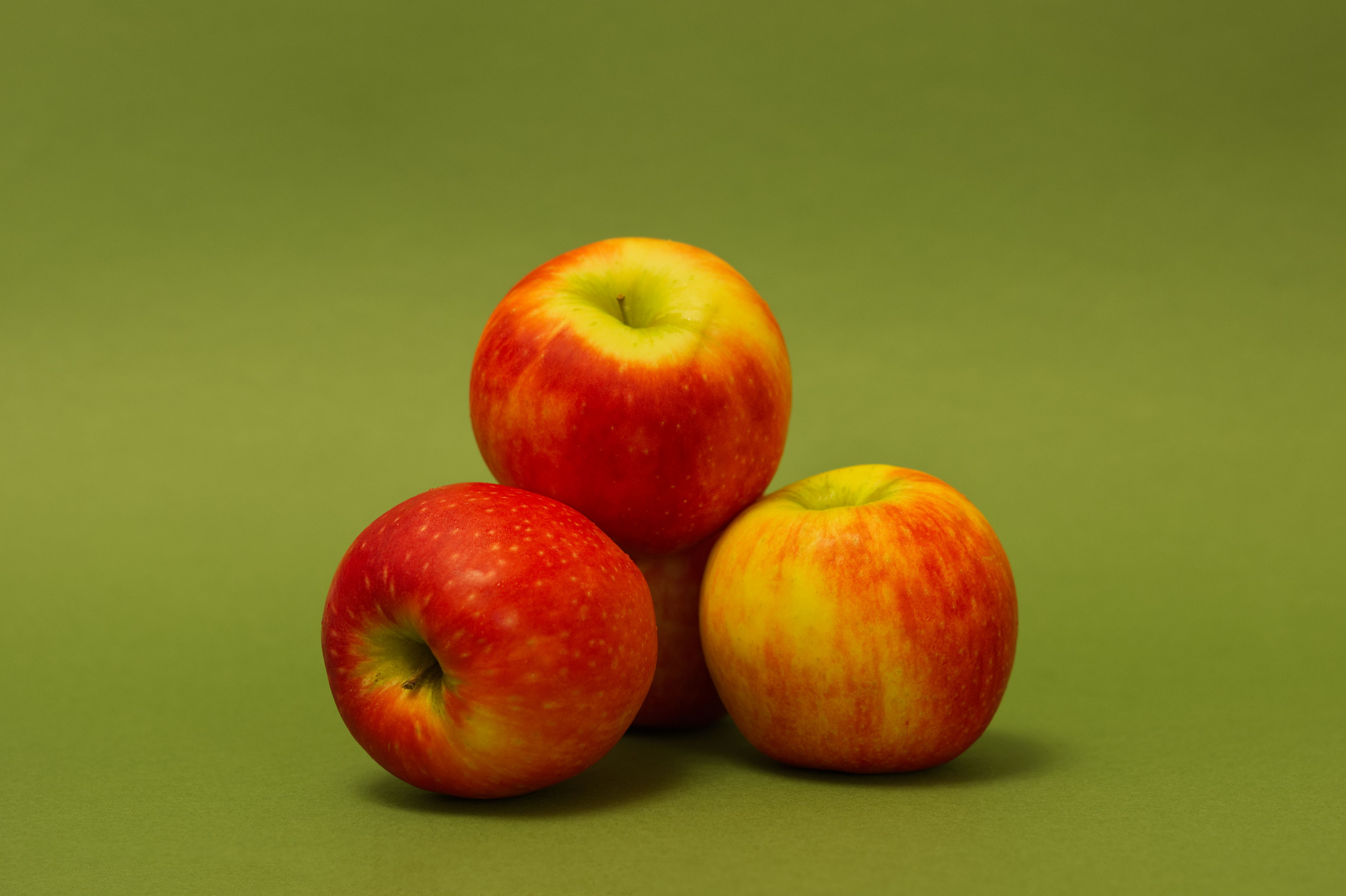 Fresh Red Apples on Vibrant Green Background · Free Stock Photo