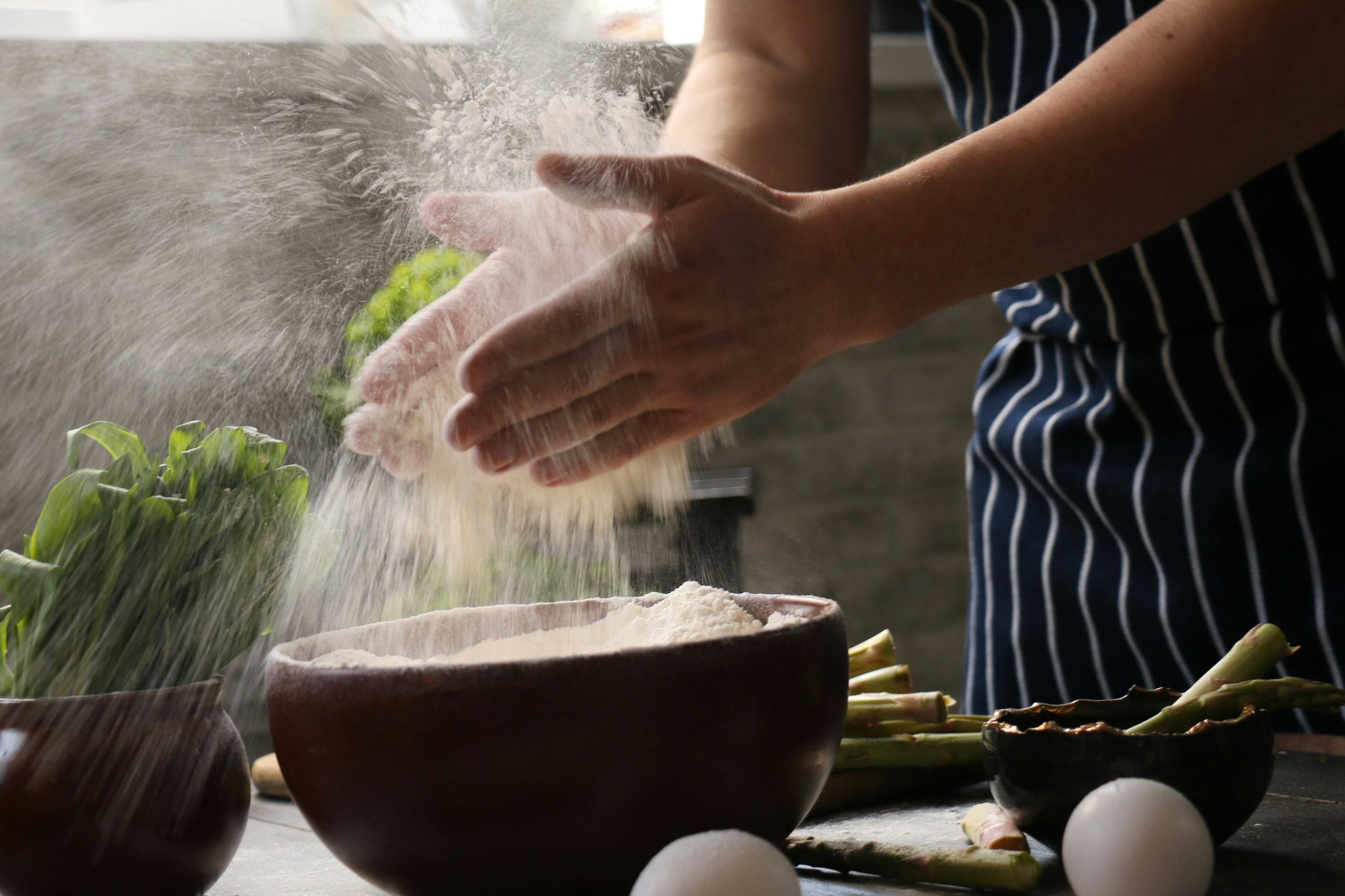 Faceless woman dusting hands with flour during cooking process · Free Stock Photo
