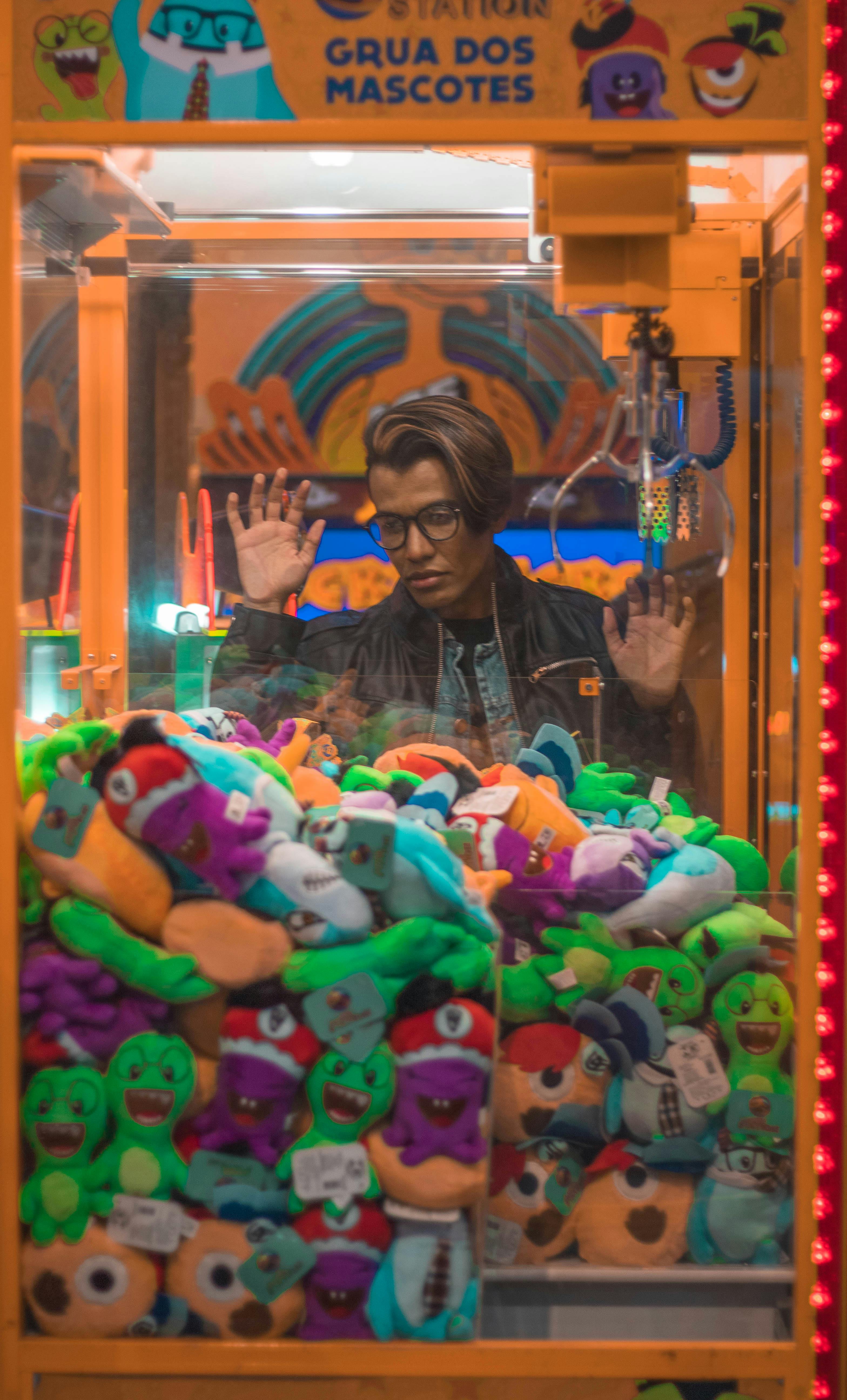 stylish guy choosing plush toy in crane machine