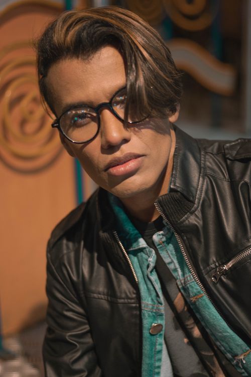 Free A fashionable man wearing a black leather jacket and glasses, showing a serious expression. Stock Photo