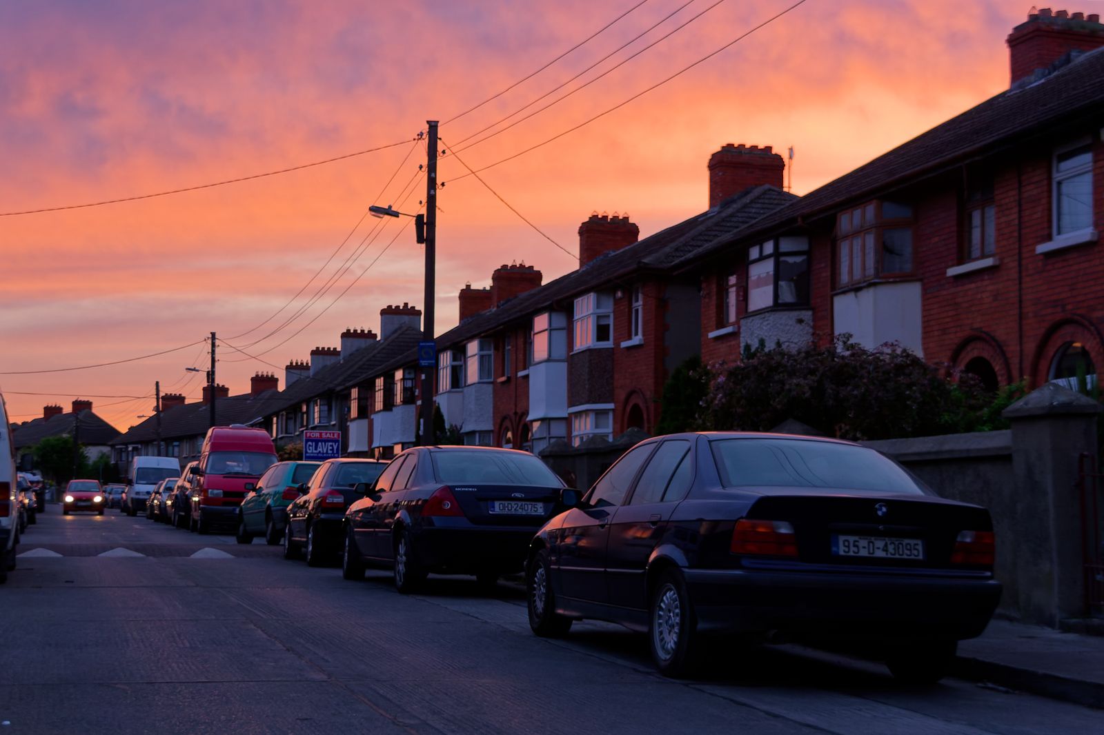 Sunset over a quiet suburban street in Dublin with parked cars and classic row houses
