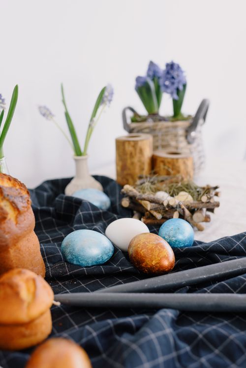 Free Colorful Easter eggs and spring flowers arranged on a table with pastries, perfect for festive celebrations. Stock Photo