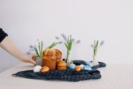 复活节的节日安排中，桌子上摆放着面包、彩色鸡蛋和鲜花