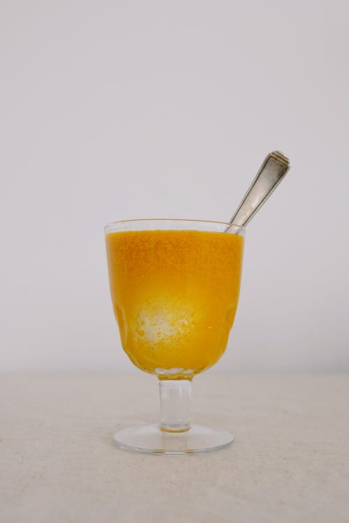 Glass of orange egg coloring liquid