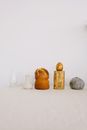 Creative composition with Easter cake and golden egg together with various vases and wood chock placed on white table against white wall as symbol of traditional Easter holiday