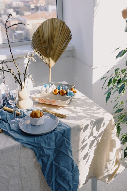 Free Stylish spring table setting with Easter decorations and sunlight casting patterns. Stock Photo