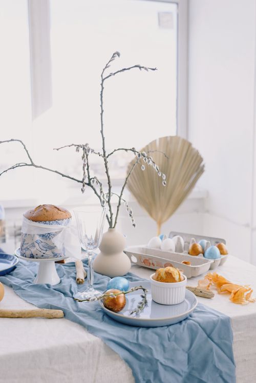 Free A beautifully arranged Easter table with muffins, colored eggs, and decorative elements indoors. Stock Photo