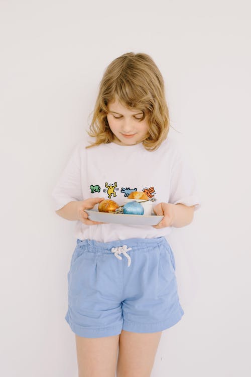 Small Girl Holding a Plate With Easter Eggs