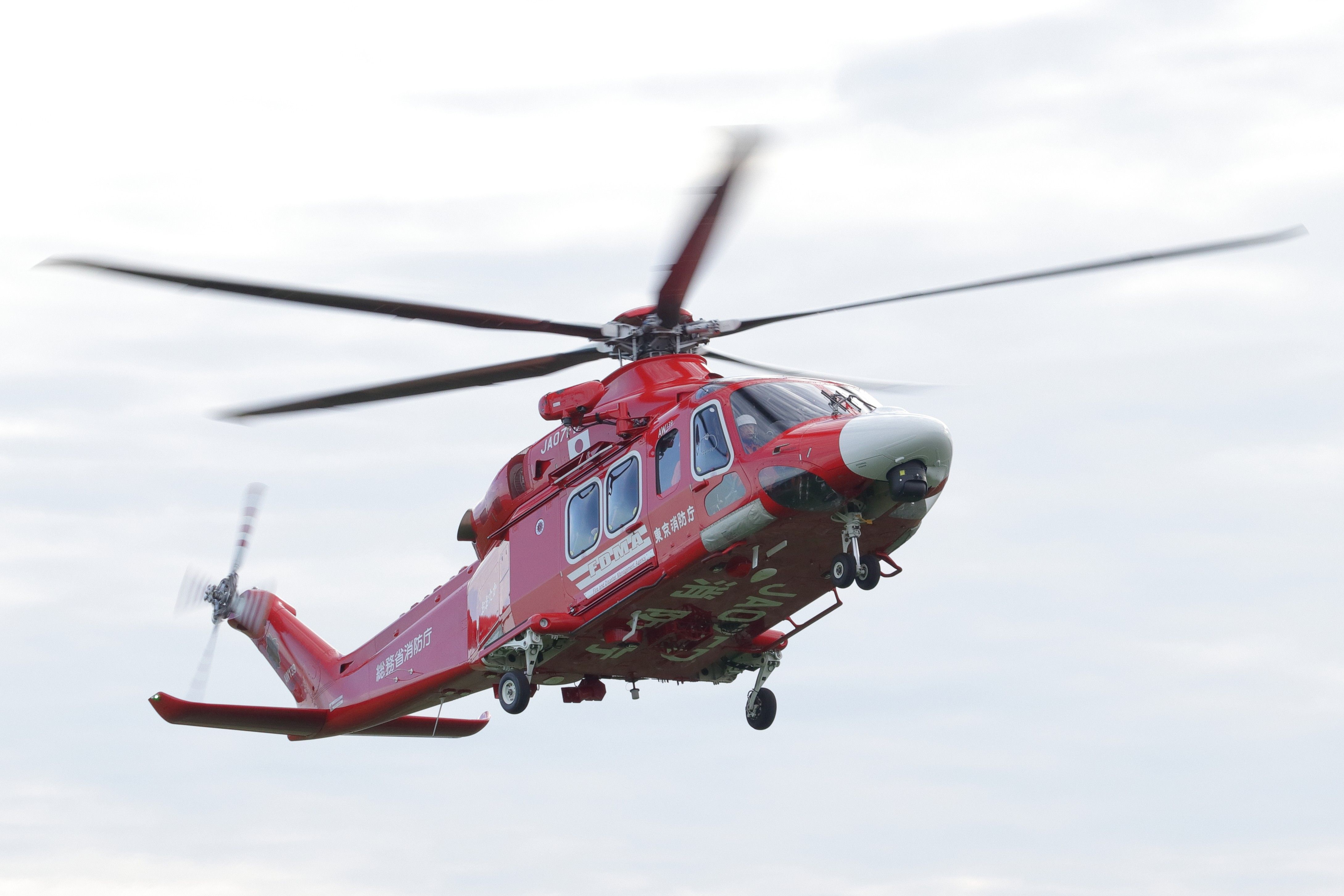 Red AW139 Helicopter in Flight with Motion Blur · Free Stock Photo