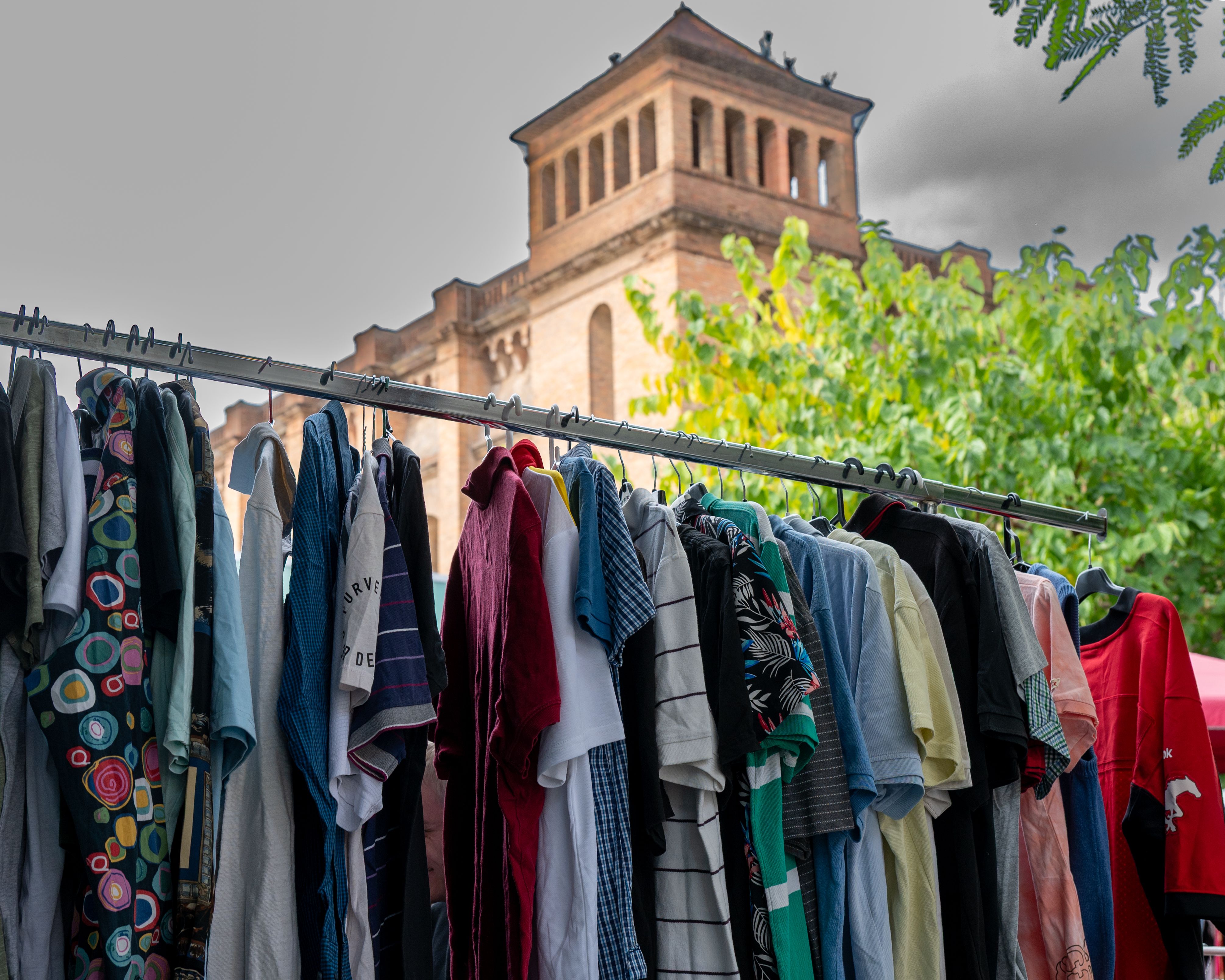 Colorful clothing rack with historical architecture · Free Stock Photo