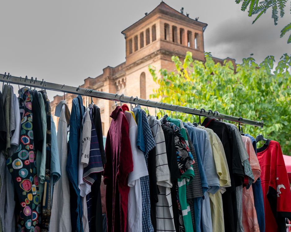 Car Clothes Rack Colorful clothing rack with historical architecture · Free Stock Photo