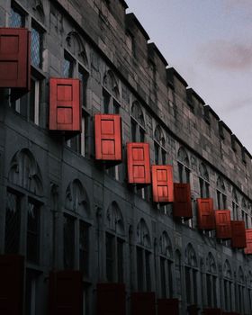 黄昏时分，一座历史建筑的建筑细节，鲜艳的红色百叶窗格外引人注目。 - 相关推荐