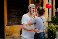 Unrecognizable woman touching face of boyfriend on city street