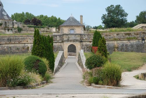 Free Beautiful stone pathway leading to a historic fort entrance surrounded by lush greenery. Stock Photo