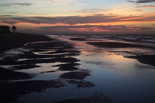 Mesmerizing twilight view of Sanibel Island beach with vivid sky reflections in tidal pools.
