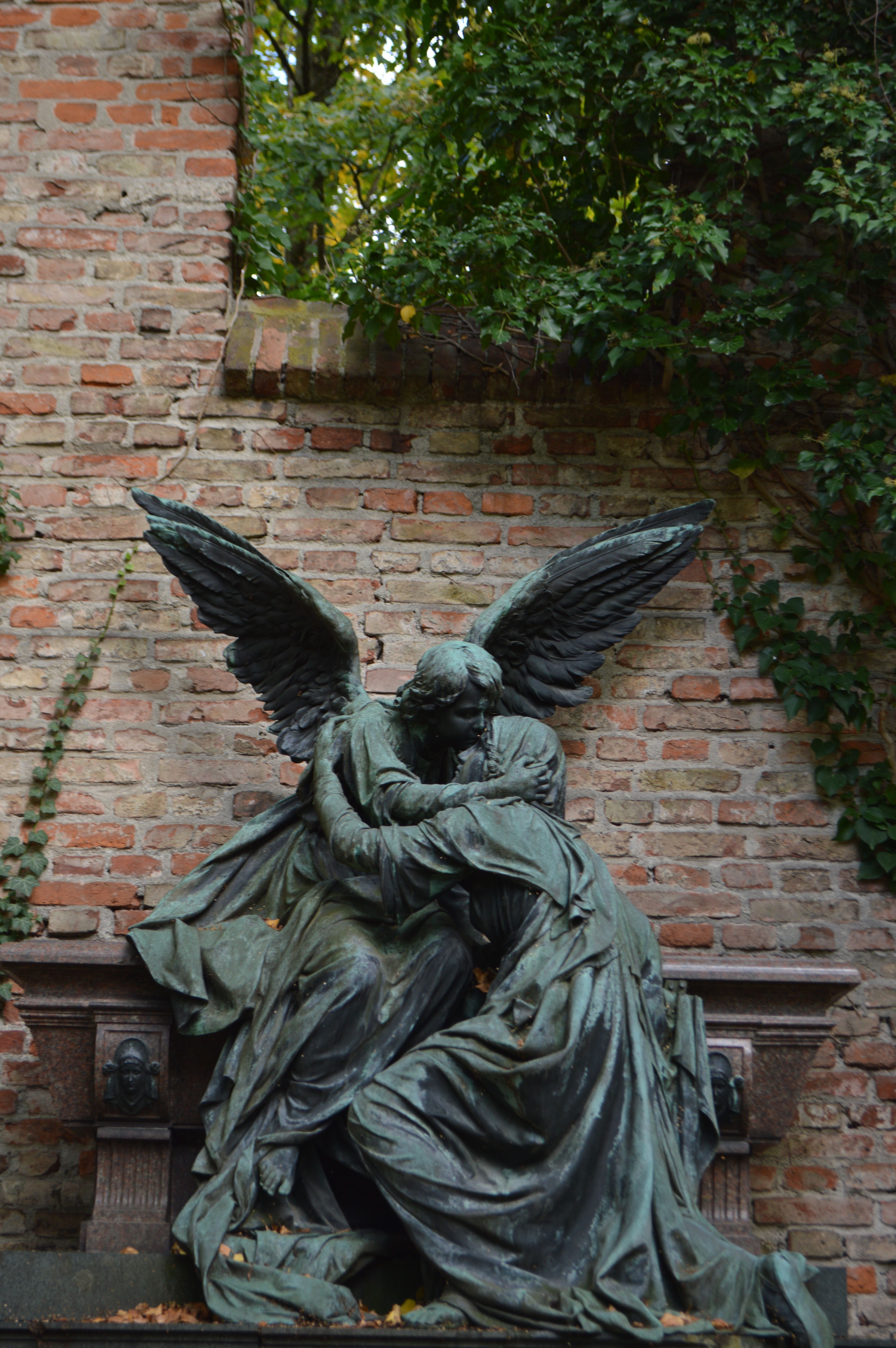 Dramatic Angel Statue in Ivy-Covered Courtyard · Free Stock Photo