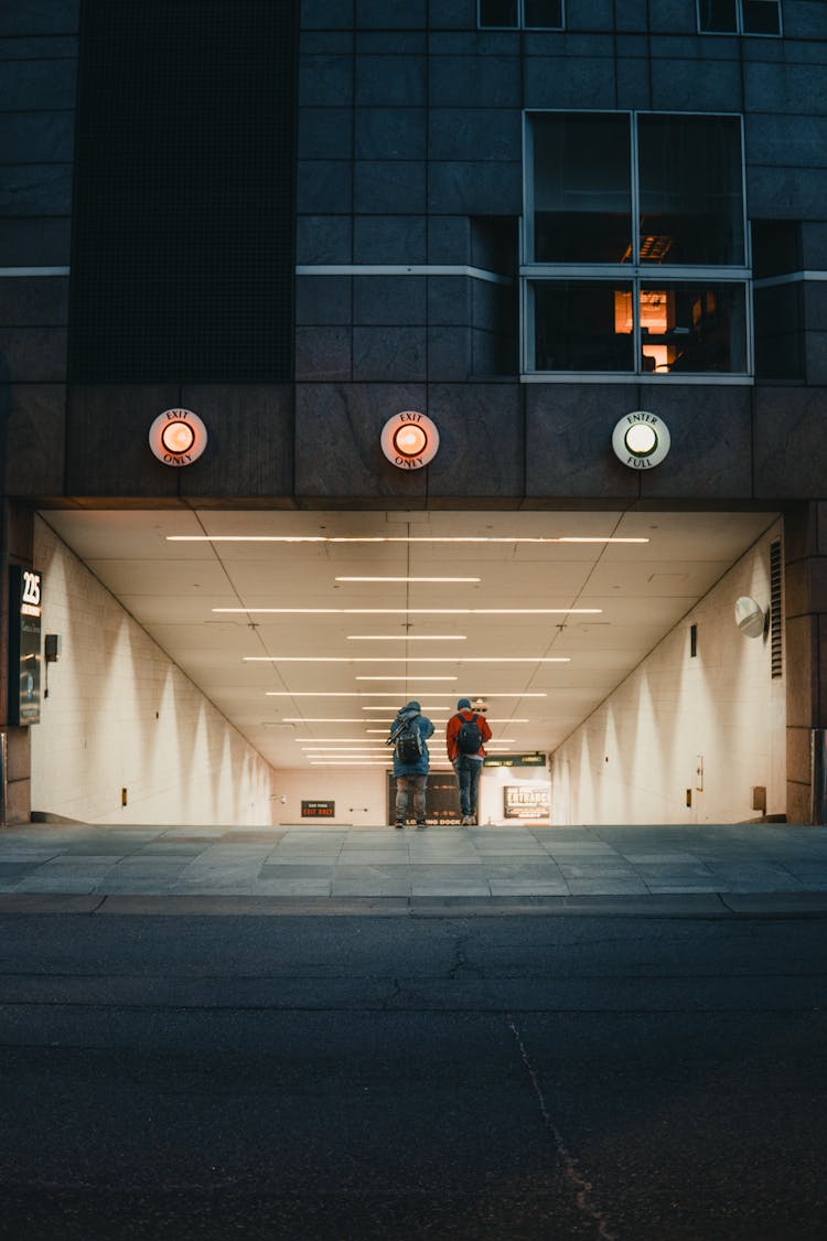 Backview Of Two People Standing On A Tunnel 