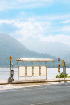 空荡荡的公交车站位于水边，远处群山环绕，天空湛蓝。 - 相关推荐