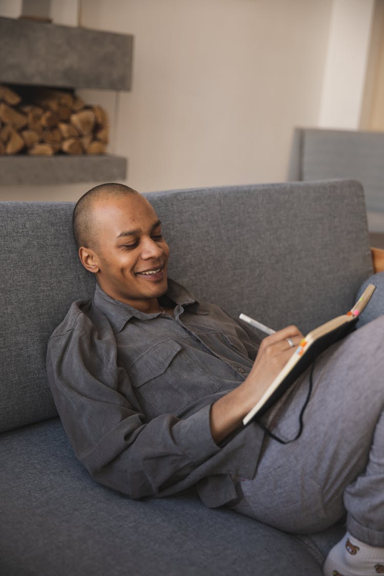 Photo Of Man Writing On A Notebook