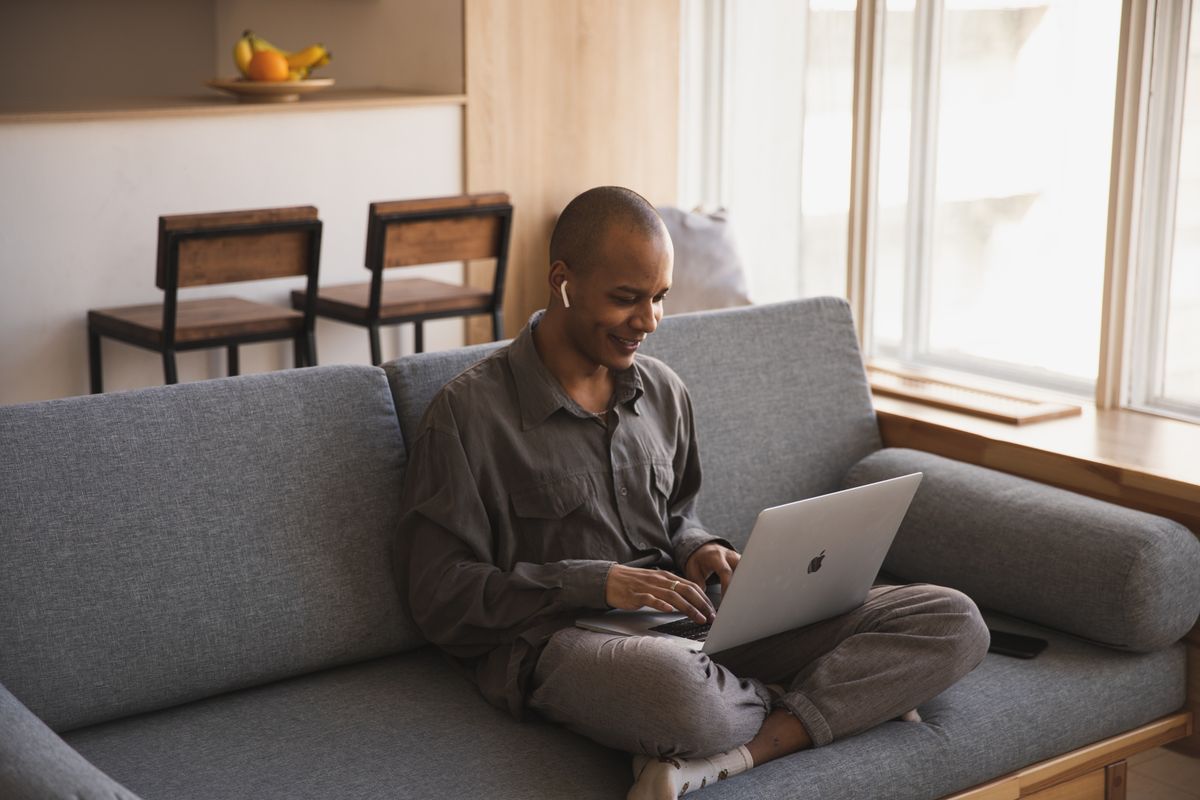 Man sitting on a sofa using a laptop at home