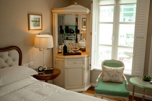 Cozy hotel room with vintage furniture, elegant lighting, and a beautiful view through the window.