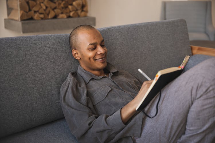 Photo Of Man Writing On A Notebook