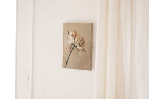 Free Picture of flower composition on beige canvas hanging on white wall near curtain Stock Photo