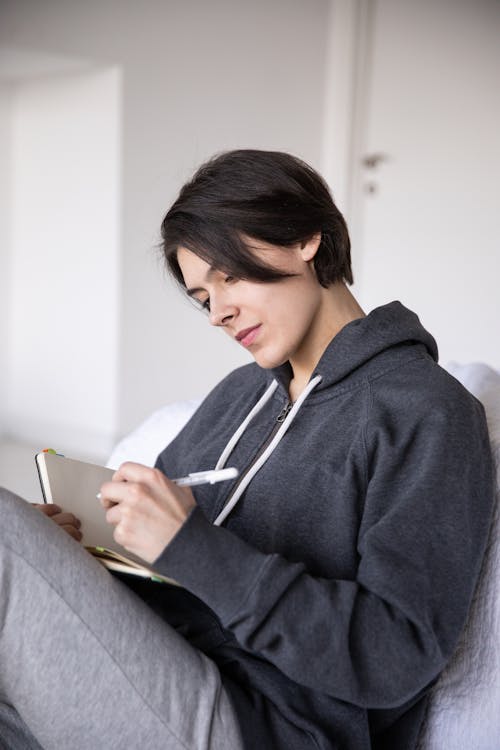 Photo Of Woman Writing On A Notebook