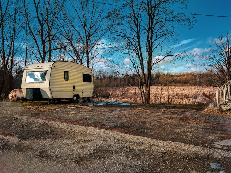 White And Gray Rv Trailer On Brown Field Under Blue Sky