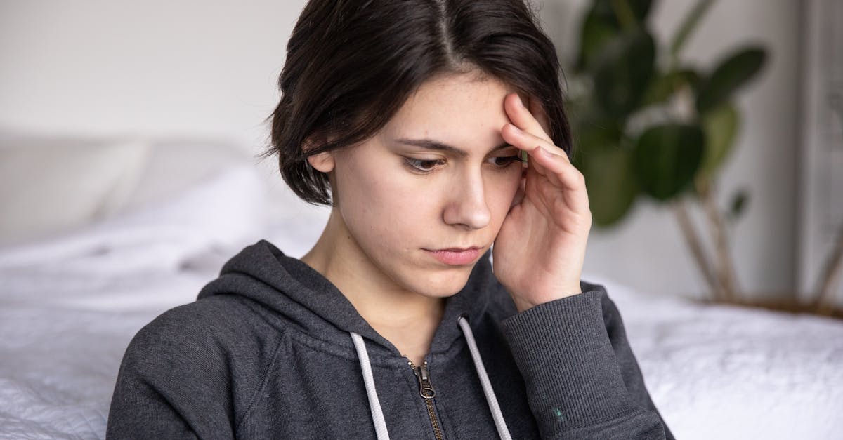 Young woman in a hoodie appearing thoughtful and pensive, captured indoors.