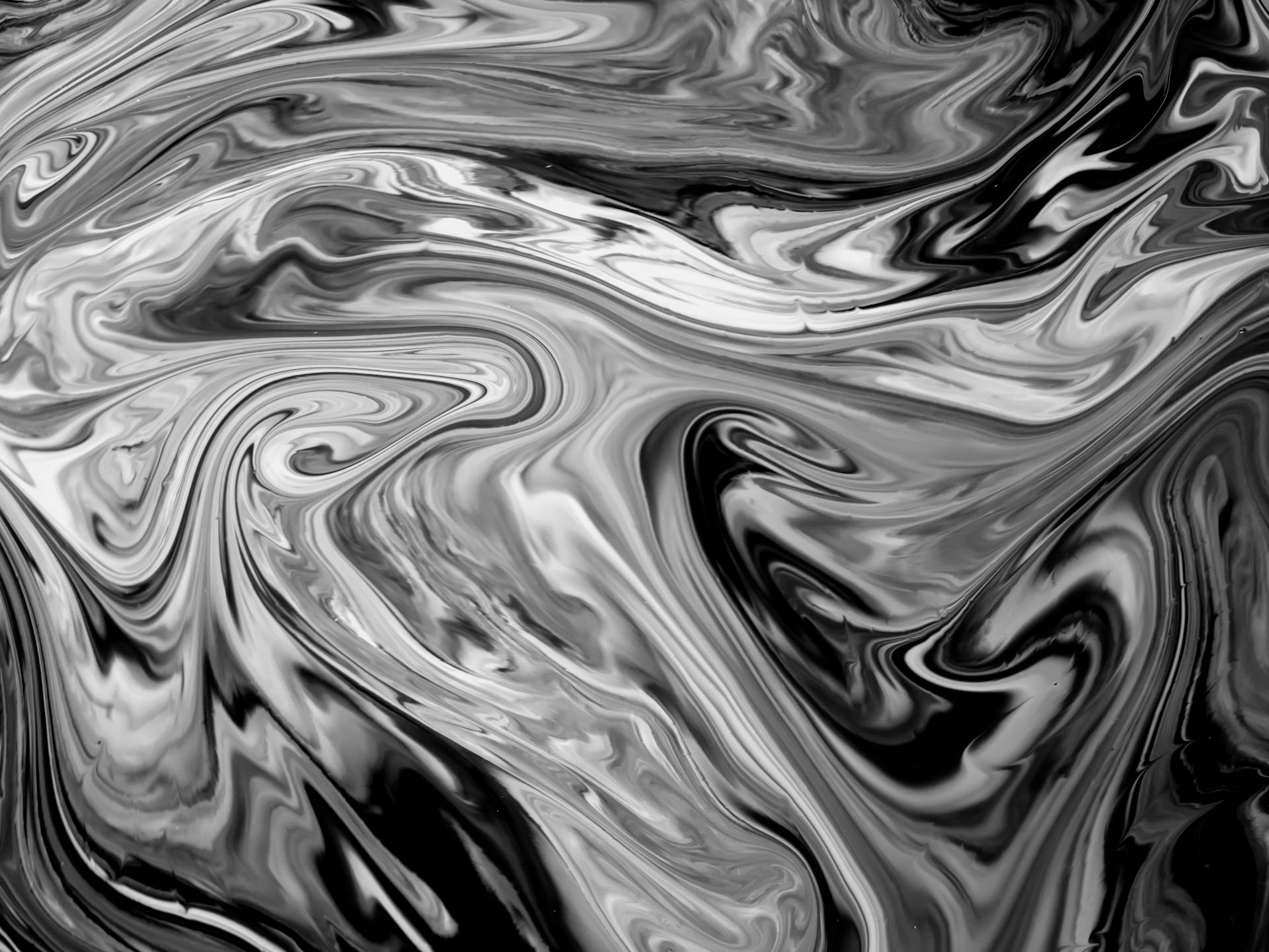 Dynamic black and white abstract swirl pattern resembling liquid waves, perfect for modern art and design applications.