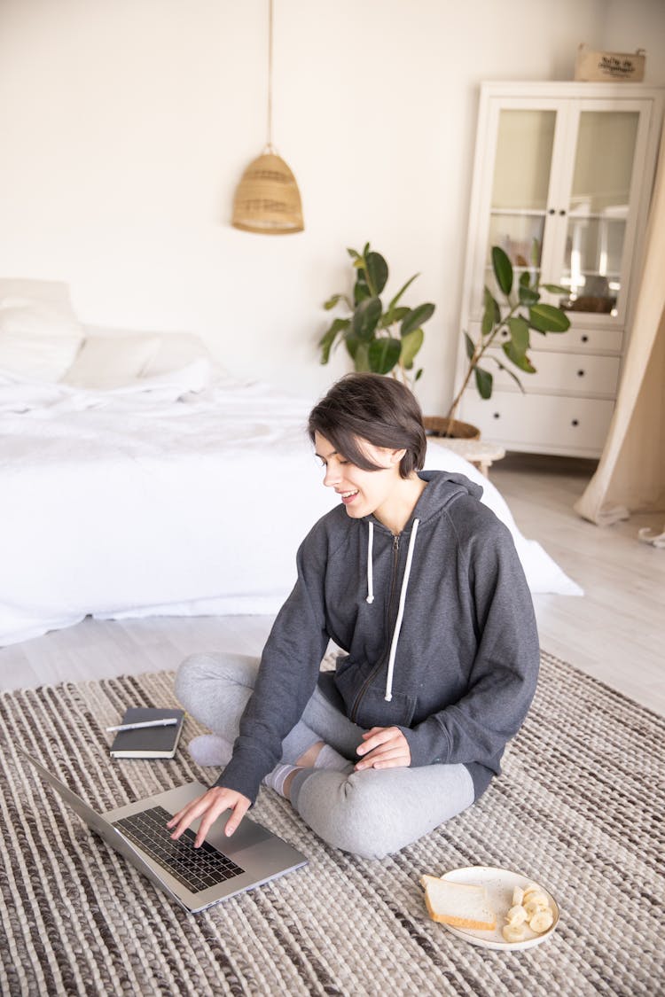 Young Woman Using Laptop On Floor