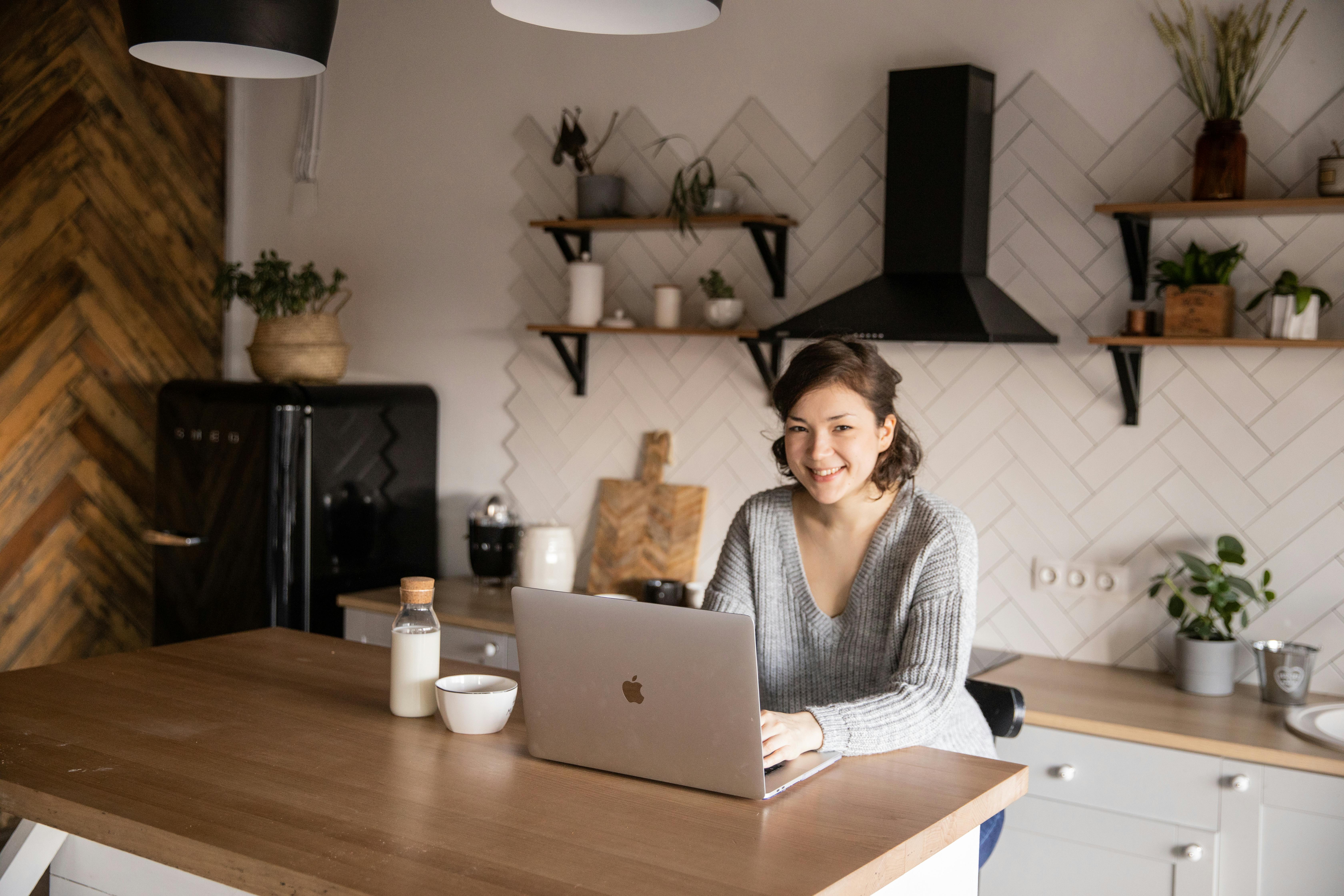 young woman using laptop in kitchen