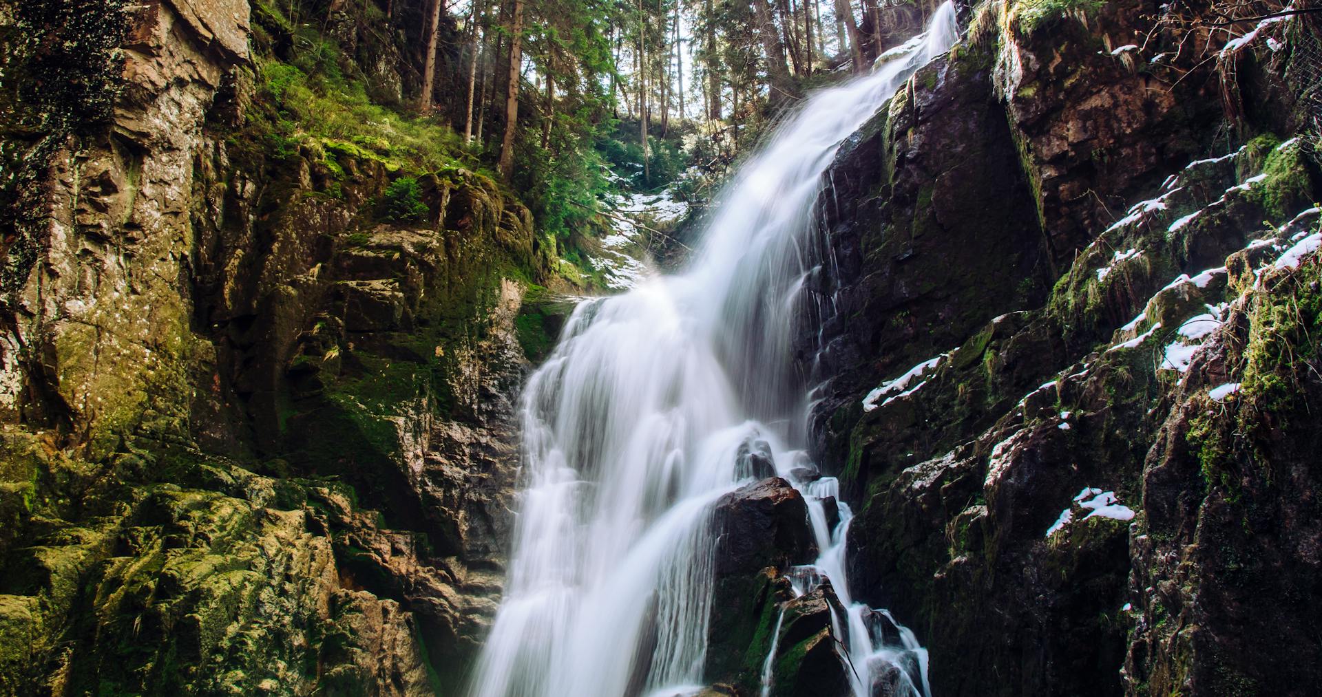 Stunning waterfall cascading over rocks in Jelenia Góra, Poland forest.