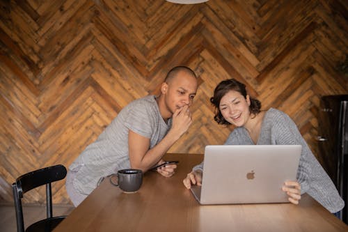 Free Cheerful friends watching video on laptop together Stock Photo