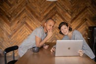 快乐的夫妇在家里用笔记本电脑时微笑着