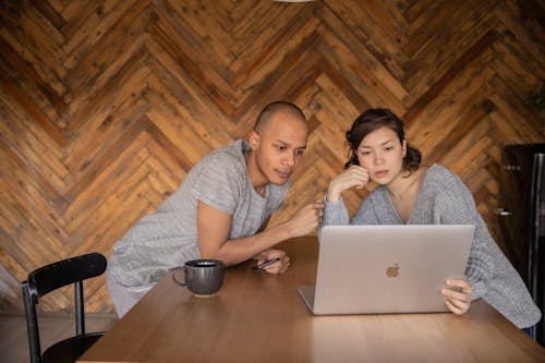 Focused couple using laptop in kitchen