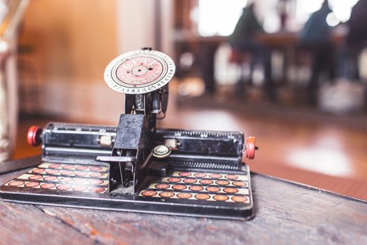 Close-up of an antique typewriter on a wooden table indoors.