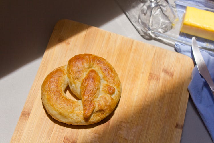 Overhead Shot Of A Soft Pretzel On A Wooden Chopping Board