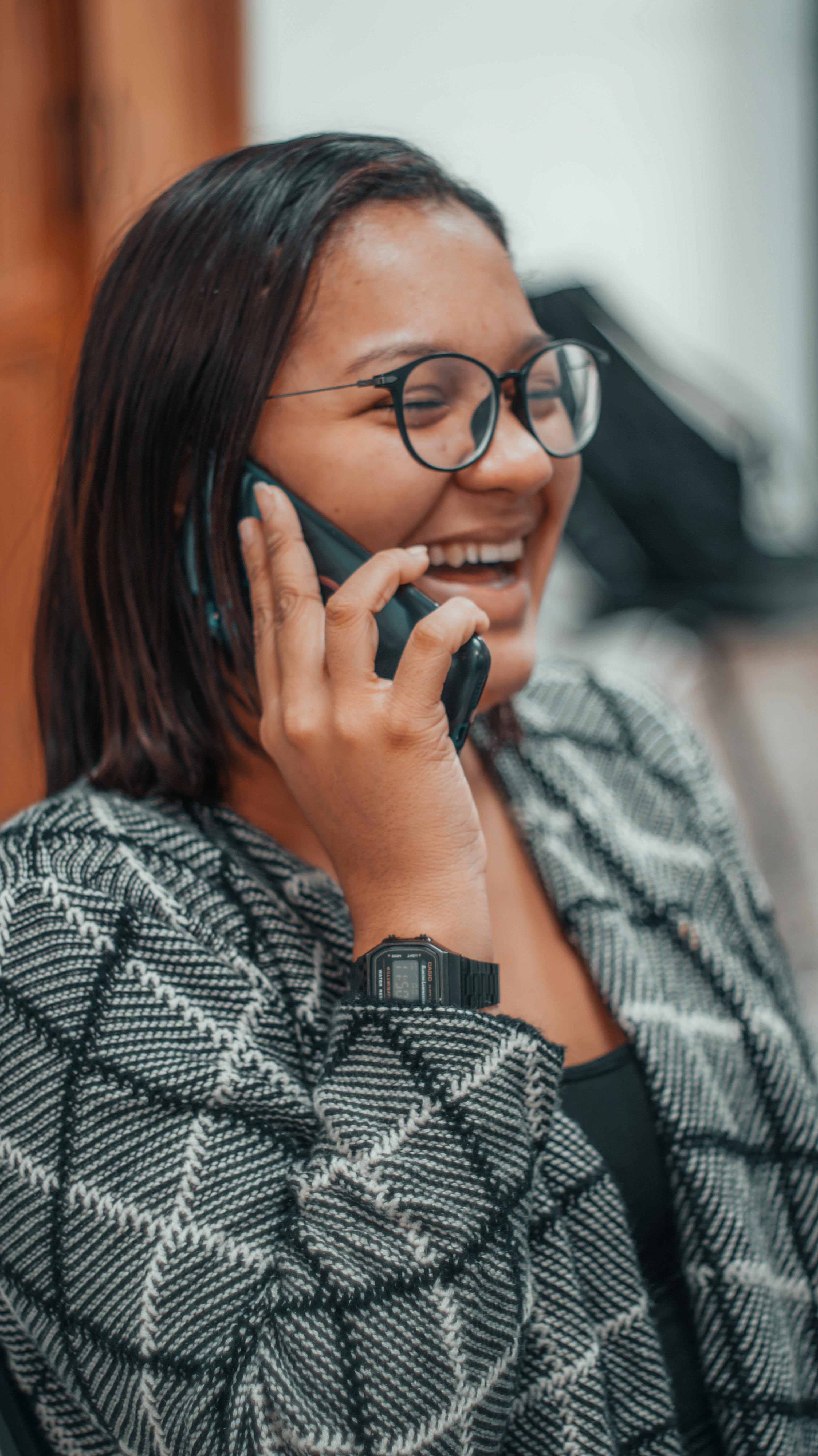 selective focus photo of a woman with eyeglasses talking on the phone