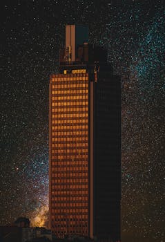 A high-rise building stands illuminated against a starry night sky in Nantes, France.