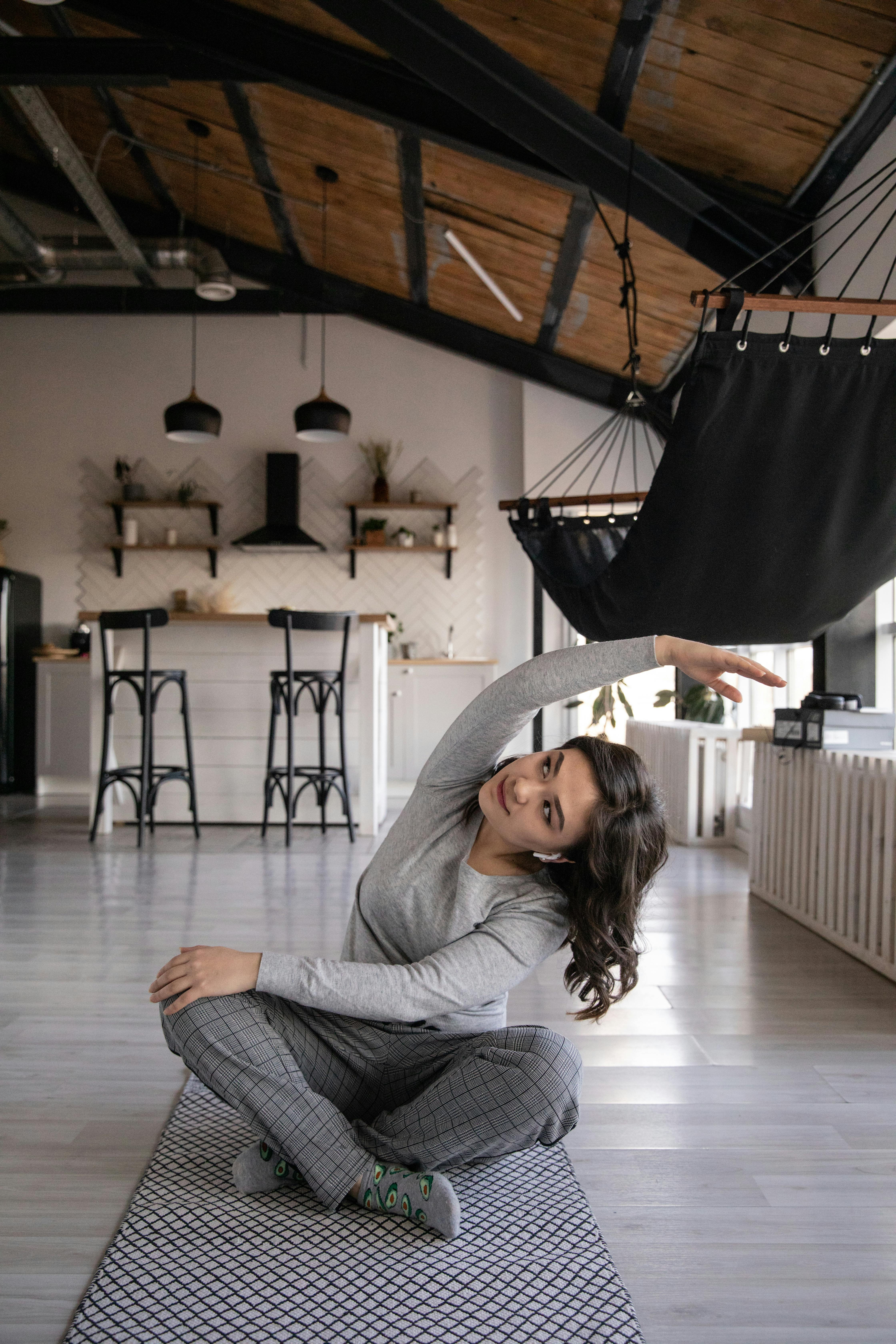 Ethnic woman sitting on Lotus pose and doing side inclination