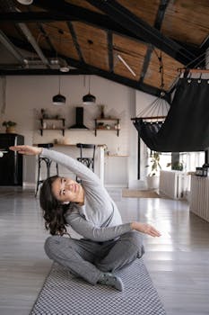 A woman in a loft apartment practicing yoga, enhancing mindfulness and relaxation indoors.