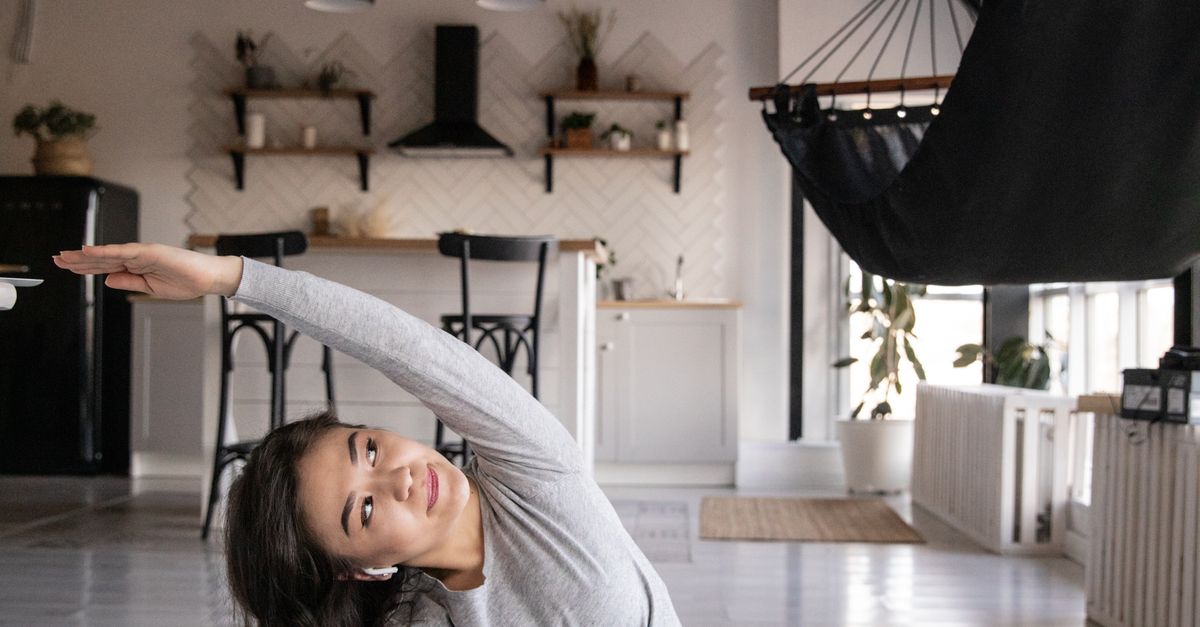 Side Inclination Flexible ethnic woman doing side inclination while practicing yoga ...