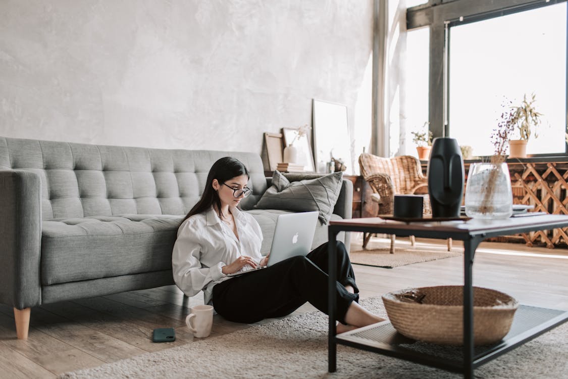 Free Woman Sitting On The Floor While Using Her Laptop Stock Photo